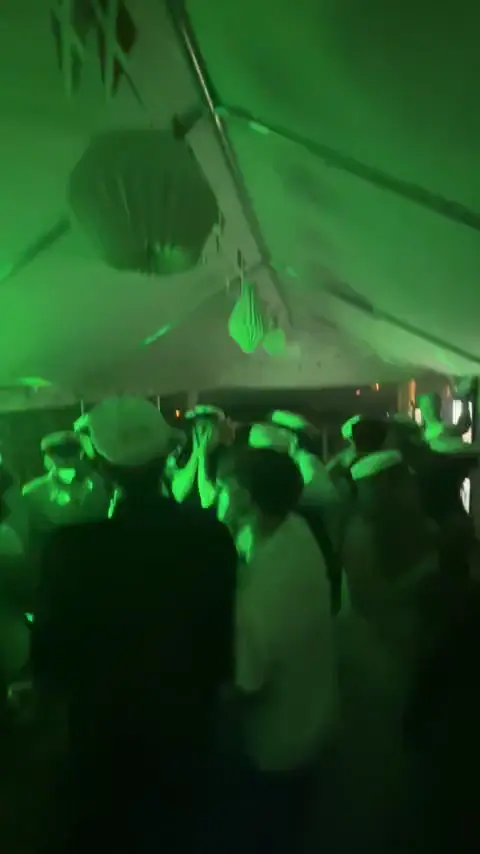 Studenter med huer danser i et festtelt til et studentergilde