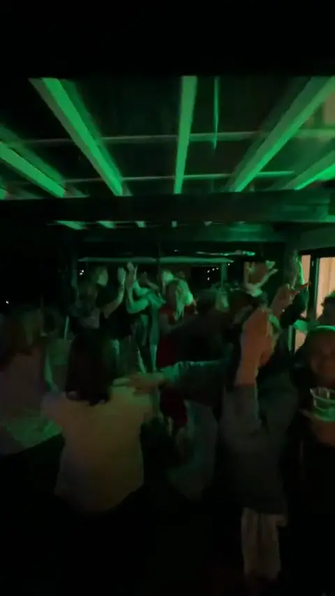 Voksne gæster danser under grønne lysstråler til en voksenfest