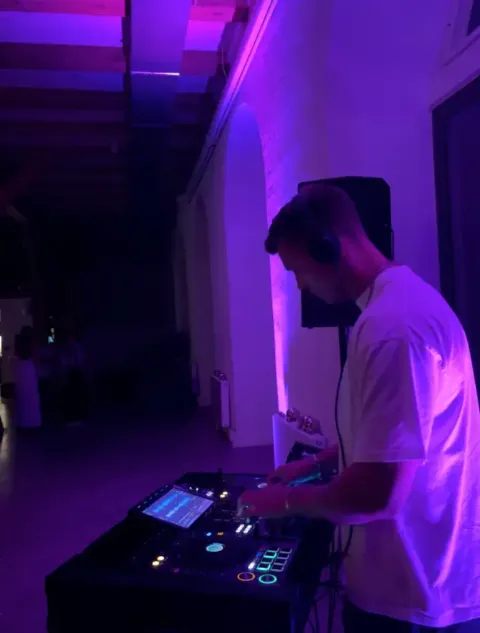 Laust Skrudland bag DJ-pulten i magenta lys til en fest