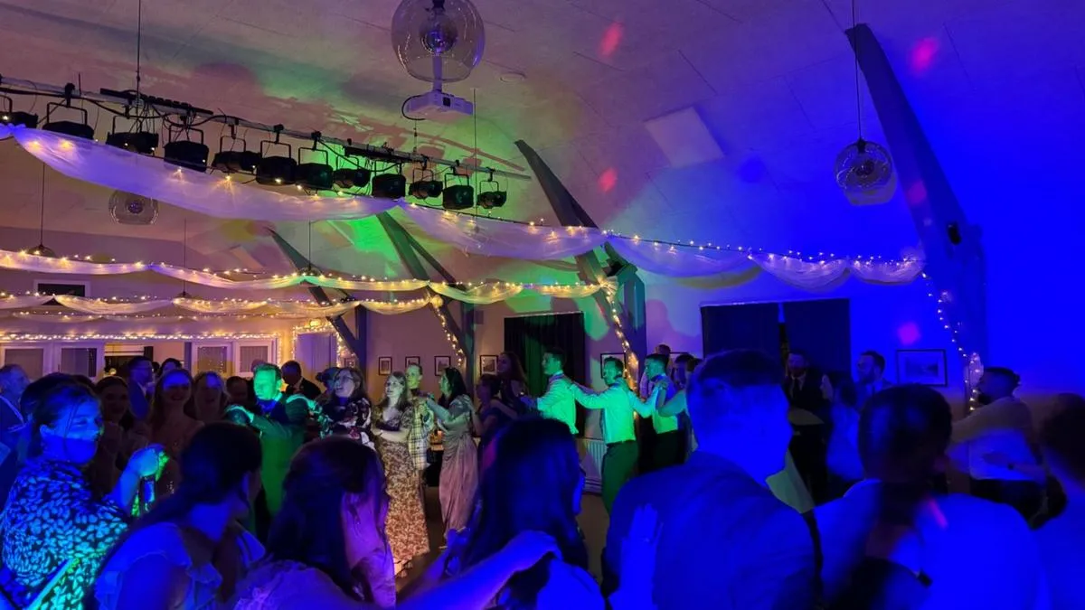 Fyldt dansegulv under lyskæder til en fest med DJ fra DJTILBUD