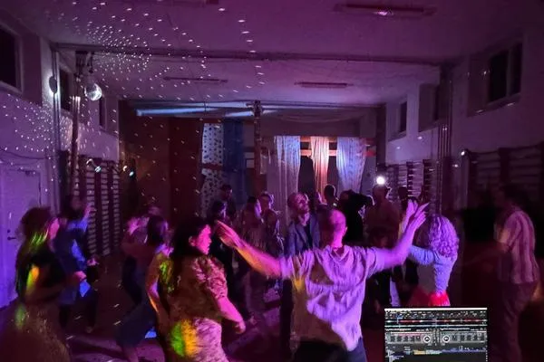 Gæster danser med armene i vejret, set fra DJ-pulten